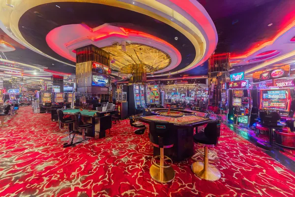 A close-up shot of golden coins falling around a spinning roulette wheel, representing immersive casino action at PAGASAS.