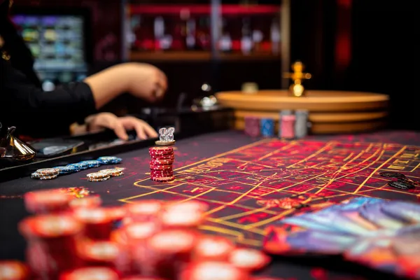 A glowing roulette wheel with cascading chips, symbolizing the engaging live and instant-win games available on PAGASAS.
